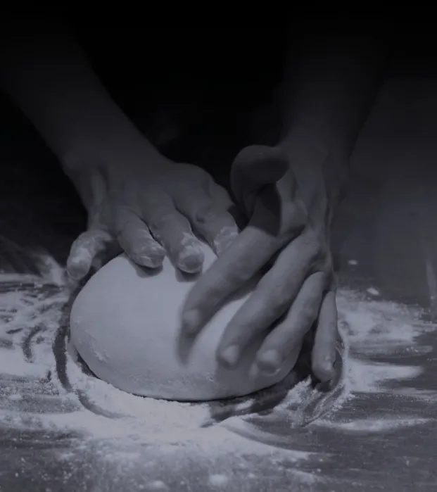 Fanny, pizzaiola chez PizzApp à Salon-de-Provence, façonnant un pâton de pizza avec passion, photo en noir et blanc.